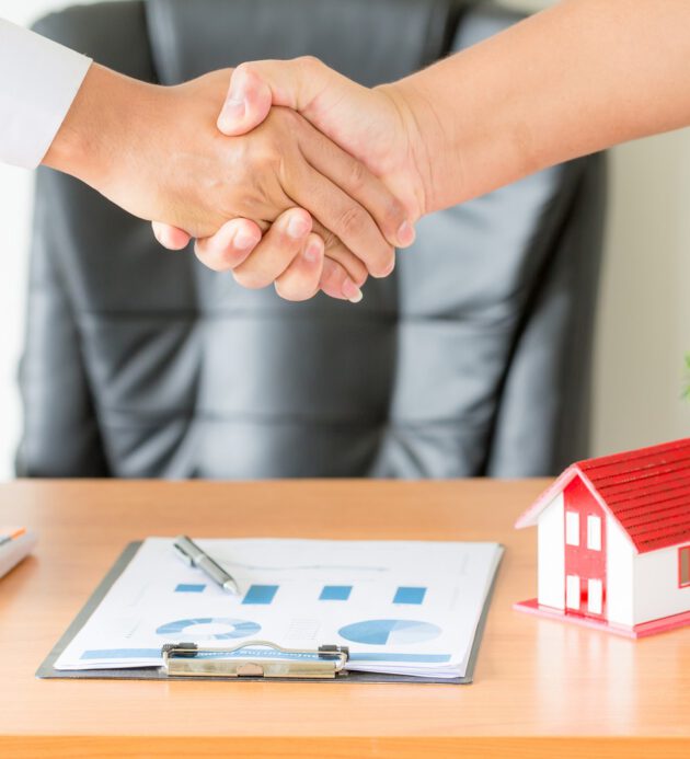 hands of agent and client shaking hands after signed contract bu Side view hands of agent and client shaking hands after signed contract buy new apartment.