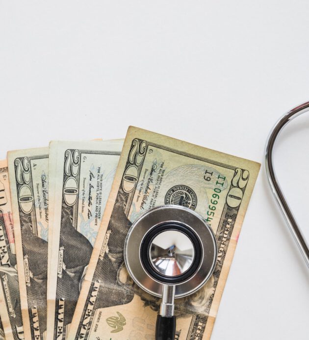 overhead-view-stethoscope-us-currency-note-white-background overhead-view-stethoscope-us-currency-note-white-background